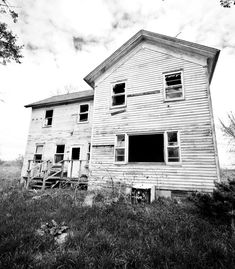 an old run down house sitting in the grass