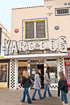 people walking in front of a store with the word yard dog on it's side