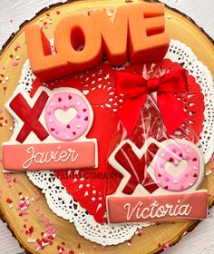 valentine's day cookies on a plate with the word love spelled in large letters