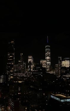 the city skyline is lit up at night with skyscrapers in the foreground and lights on all sides