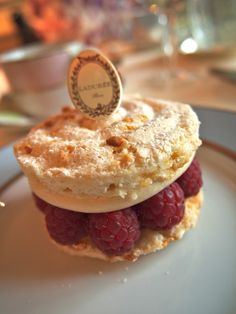 a small pastry with raspberries is on a plate