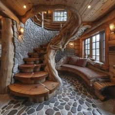 the interior of a log cabin with stone flooring and spiral staircase leading up to a bed