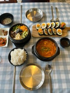 a table topped with lots of different types of food on top of a blue and white checkered table cloth