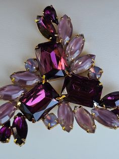 "Unmarked beauty! Brooch is comprised of 3 large emerald cut purple stones which are adorned by large navettes in lavender and purple and accented by a few purple pear cut stones and three round cut lavender moonglow stones. All stones are prong set. Breathtaking! It is quite large, measuring 2.5 x 2.5\" at its widest and longest. In very good condition.  Acquired at a high end estate of someone who obviously appreciated fine vintage  jewelry and antiques. As with any vintage jewelry, this piece may have evidence of handling, storage or prior love - including minor scratches, oxidation, patina or other blemishes." Purple Brooch Jewelry For Evening, Vintage Purple Brooch For Party, Vintage Purple Brooches For Party, Antique Costume Jewelry, Vintage Rhinestone Jewelry, Vintage Rhinestone Brooch, Purple Rhinestone, Silver Pin, Moon Glow