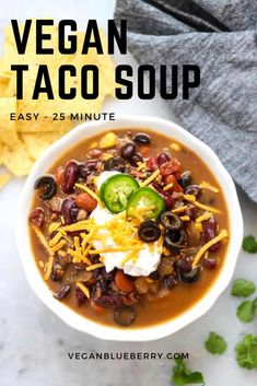 vegan taco soup in a white bowl with sour cream, black beans and jalapenos