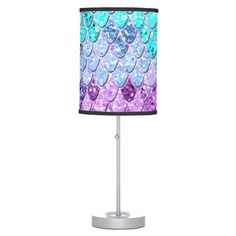 a purple and blue table lamp with hearts on it's shade, sitting on a white base