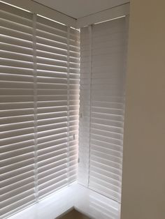 the corner of a window with white blinds