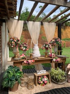 a table with flowers and cake on it in front of an outdoor area that looks like a garden