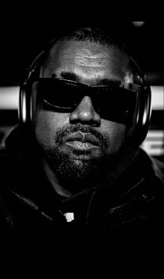 a man wearing sunglasses and headphones in the dark