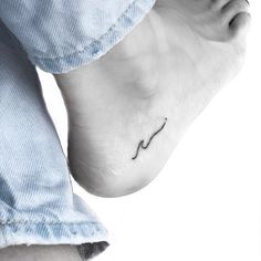 a person's foot with a small wave tattoo on their left side and the word love written in black ink