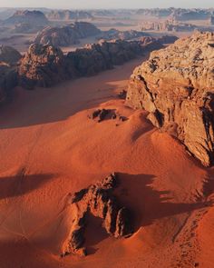 an aerial view of the desert with rocks and mountains in the background, taken from above