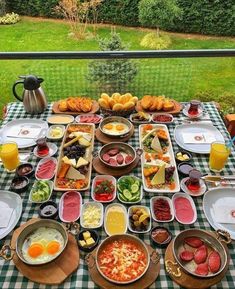 a table full of food on top of a green and white checkered table cloth