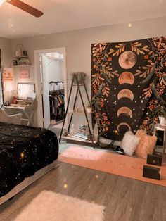 a bedroom decorated in black and white with a large tapestry on the wall next to a bed