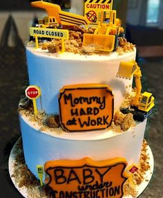 a three tiered cake decorated with construction signs and trucks on it's sides