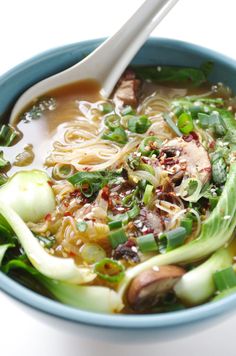 a blue bowl filled with soup and vegetables