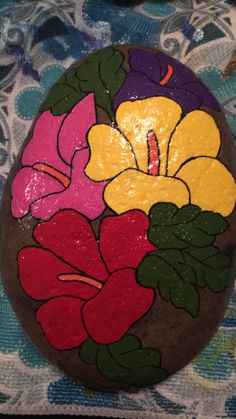 a painted rock with flowers on it