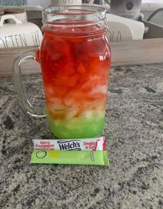 a jar filled with jelly sitting on top of a counter next to a bag of candy