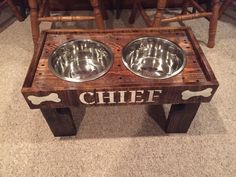 two stainless steel bowls sit on top of a wooden bench