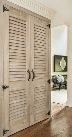 an open closet door with shutters on the inside and wood floors in front of it