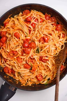 a skillet filled with spaghetti and tomatoes