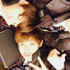 two young men laying on the floor with their hands in the air and one holding a laptop