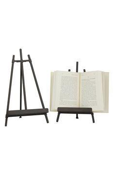 an open book sitting on top of a wooden easel next to an open book