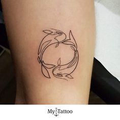 a small tattoo on the leg of a woman's thigh shows two dolphins in a circle