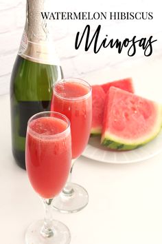 two glasses of watermelon hibiscus wine next to a bottle and slice of watermelon