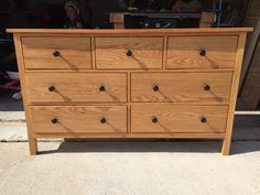 a wooden dresser sitting on top of a sidewalk