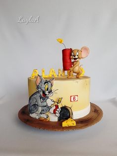 a birthday cake decorated with an image of a cat and mouse