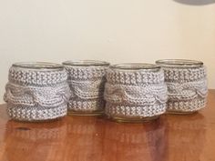 three crocheted jars sitting on top of a wooden table