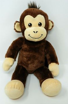 a brown stuffed monkey sitting on top of a white table