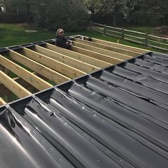 a man standing on top of a metal roof