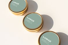 three round tins sitting on top of a white surface with the word lodge written in it