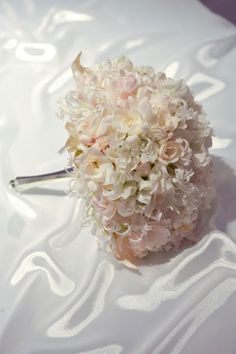 the bridal bouquet is laying on the white sheeted tablecloth, ready to be used as a wedding decoration