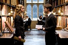 two people standing in a library talking to each other