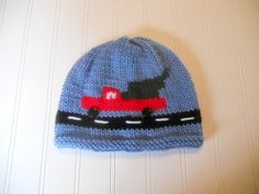 a knitted hat with a dog on the front and red truck on the back