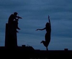 the silhouettes of two people reaching up to catch a frisbee