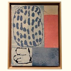 an abstract painting with black and white spots on it's face, in a wooden frame