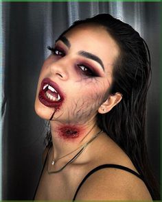 This makeup look perfectly captures the essence of a modern vampire, blending sensuality with a hint of menace. The focal point is the intense eye makeup, featuring dark, smokey eyes with a gradient of red and black eyeshadow that creates a deep, alluring gaze. The use of dramatic false lashes adds volume and intensity to the eyes, making them the centerpiece of this look.   Photo credit by: @manilacarbonaro.mua Vampire Halloween Makeup Ideas, Vampire Special Fx Makeup, Red Goth Eyeshadow, Horror Vampire Makeup, Halloween Spooky Makeup, Red Black Eye Makeup, Vampire Makeup Looks Halloween, Scary Vampire Costume, Scary Vampire Makeup