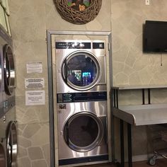 a washer and dryer in a room with a wall hanging on the wall