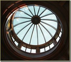 a round window with a skylight in the center and an image of a clock on it