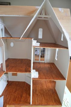 the inside of a doll house with wood flooring and white trim on the walls