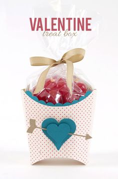 valentine treat box filled with candies and chocolates in a paper bag on top of a white table