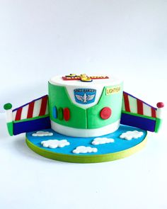 a green and white toy bus sitting on top of a blue platform with clouds around it