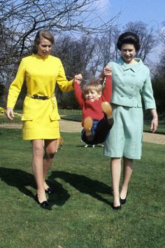 two women and a child are walking in the grass