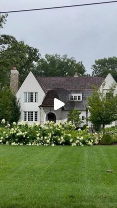 a large white house sitting on top of a lush green field