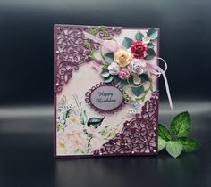 a close up of a greeting card with flowers on it and a green leaf next to it