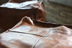 two brown leather bags sitting next to each other