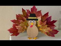 a turkey with a hat and leaves on it's head sitting on a shelf